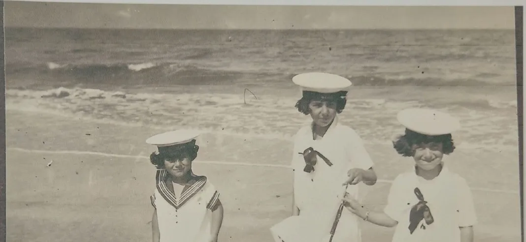 Trois enfants en costume de matelot sur la plage