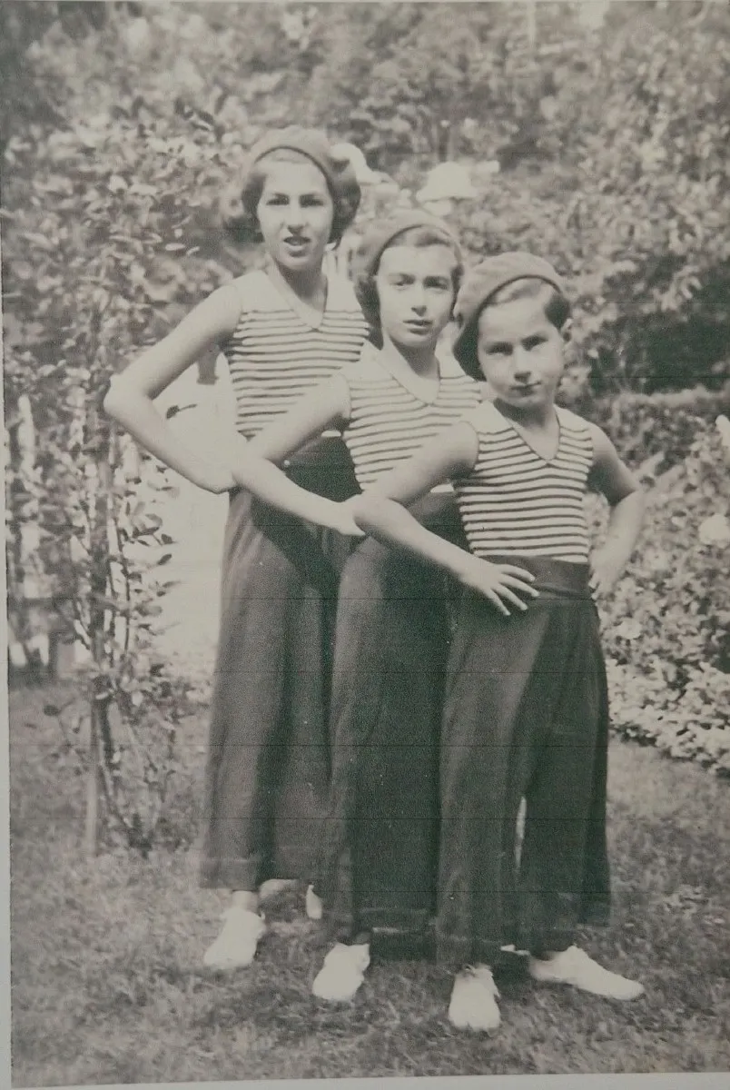 Trois enfants en marinière dans un jardin